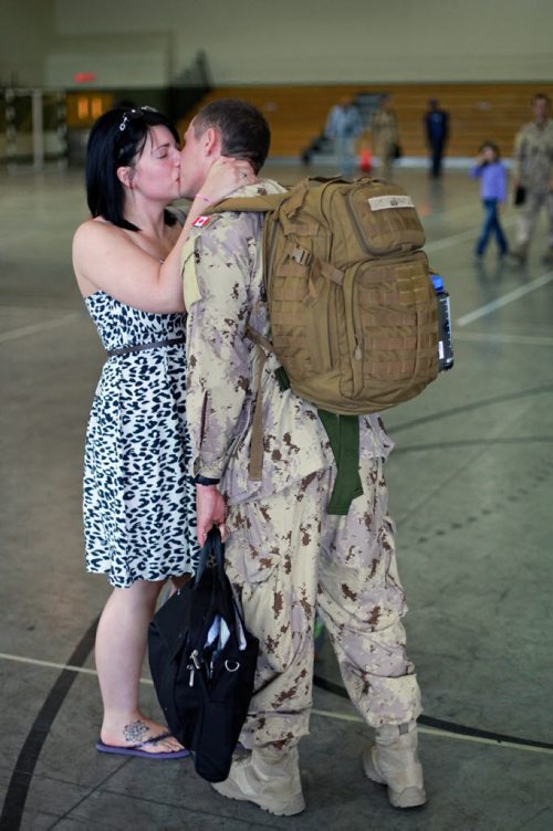 Brandon Sun 08072013 Corporal Dan Gardiner kisses his wife Callie goodbye inside the Multi-Purpose Training Facility at CFB Shilo on Monday morning prior to deploying to Kabul as part of the final rotation of Canadian soldiers serving in Afghanistan. Gardiner's deployment, his first to Afghanistan, will be approximately four month's.  (Tim Smith/Brandon Sun)