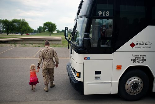 Brandon Sun 08072013 Corporal Krister Pohjolainen shows his two-year-old daughter Elise the bus he'll be taking when leaving the Multi-Purpose Training Facility at CFB Shilo on Monday morning to deploy to Kabul as part of the final rotation of Canadian soldiers serving in Afghanistan. Pohjolainen's deployment, his first to Afghanistan, will be approximately four month's.  (Tim Smith/Brandon Sun)