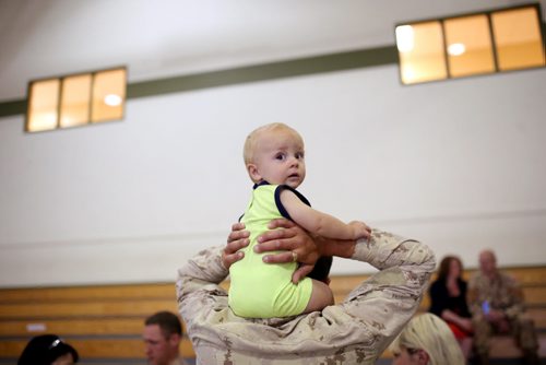 Brandon Sun 08072013 Corporal Connor Burton holds his 11-month-old son Avery on his shoulders in the Multi-Purpose Training Facility at CFB Shilo on Monday morning prior to Burton deploying to Kabul as part of the final rotation of Canadian soldiers serving in Afghanistan.   (Tim Smith/Brandon Sun)