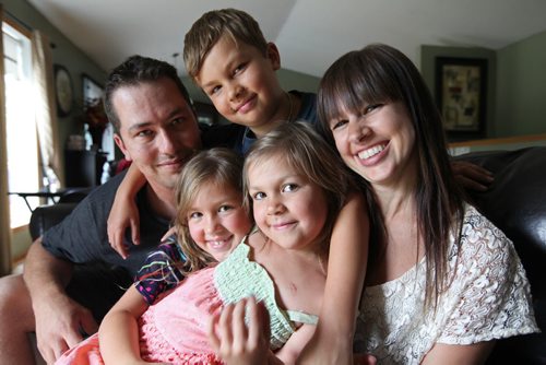 The Penner family - Dad -  Jordan, Mom - Jodi and Ryland - 9yrs, Alexis -  7 yrs  and Sophia - 6 yrs  (centre in dress) cuddle together on the couch in their home in Landmark.  The close knit family are happy with the care Sophia received from the children's hospital after she was diagnosed with cancer when she was 2 and a half years old.  See Geoff Kirbyson's story.   July 13, , 2013 Ruth Bonneville , Winnipeg Free Press