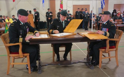 Brandon Sun Incoming Base Commander Lt-Col. Stephen Joudrey, left, signs the command papers with Col. Derek Macaulay, Commander 1 Area Support Group, and outgoing Base Commander Lt-Col. Richard Goodyear, right, during Tuesday's Change of Command Ceremony at CFB Shilo. Lt-Col. Jourdey is returning to Shilo having served as Deputy Base Commander and Chief of Staff as well as Deputy Commanding Officer with 2PPCLI. (Bruce Bumstead/Brandon Sun)