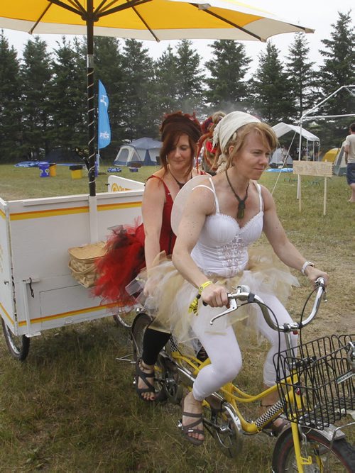 At right, Erica Bird and Cari Kappy are animators and campers in the festival campground in Birds Hill Provincial Park, they ride a tandem bike pulling their Advice Booth around the campground for anyone who needs to hear two opposing views to a question they might have.   Randy Turner  story Wayne Glowacki/Winnipeg Free Press July 10 2013