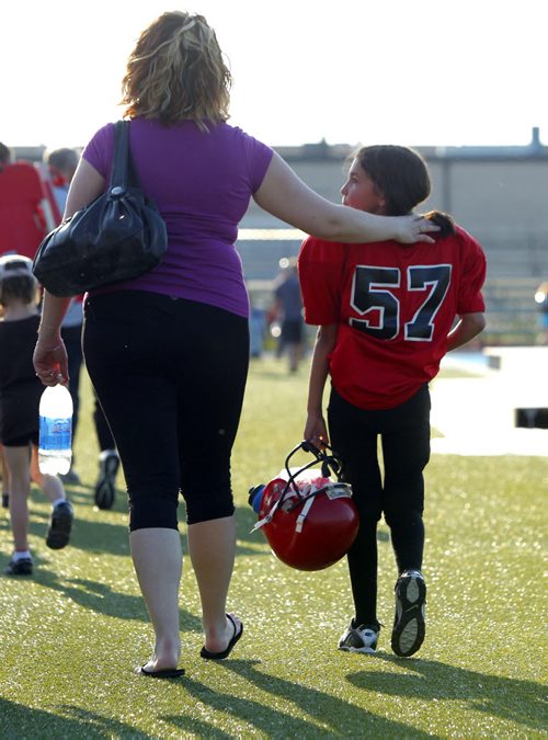 Manitoba Girls Football Association league play between the St. Vital Mustangs and the North Winnipeg Nomads Jr teams. The MGFA is a stand alone program that gives girls that want to play against other girls the oppotunity and still alows the girls that wish to play fall football to do so. #57 Sequoia Shalley with family member after the game. BORIS MINKEVICH / WINNIPEG FREE PRESS June 19, 2013