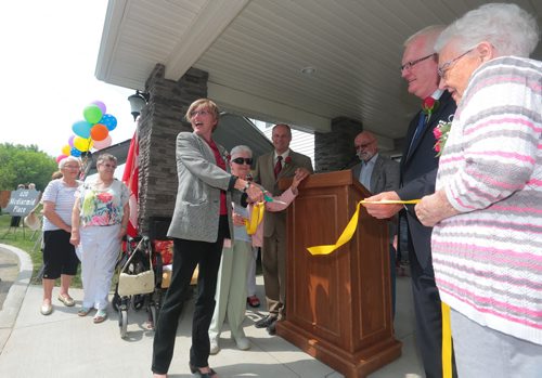Brandon Sun Mayor Shari Decter Hirst cuts the ribbon, held by residents Jeannette Holm, left, and Glenora Slimmon, right, to official open the Western Manitoba Seniors Non-profit Housing Co-op, on Wednesday morning. (Bruce Bumstead/Brandon Sun)