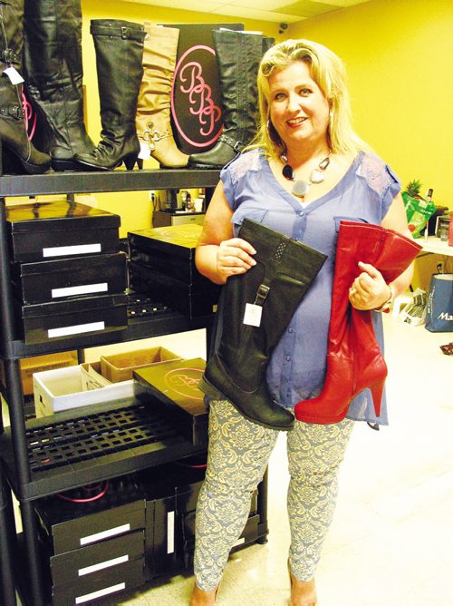 Canstar Community News Pamela Ammeter holds two of the new boot styles she plans to sell this fall. (ANDREA GEARY/CANSTAR COMMUNITY NEWS)