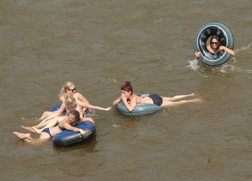 Brandon Sun A group of friends hold on to their inflatable rafts as they float down the Little Saskatchewan River from the Kirkham bridge to beat the heat on Thursday afternoon. WEATHER STATS HERE (Bruce Bumstead/Brandon Sun)