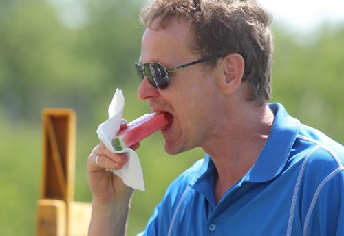 Brandon Sun Brian Deutscher cools off with a watermelon slice on the seventeenth tee off during Thursday's Westman Dreams for Kids charity golf tournament at the Shilo Golf Course. (Bruce Bumstead/Brandon Sun)