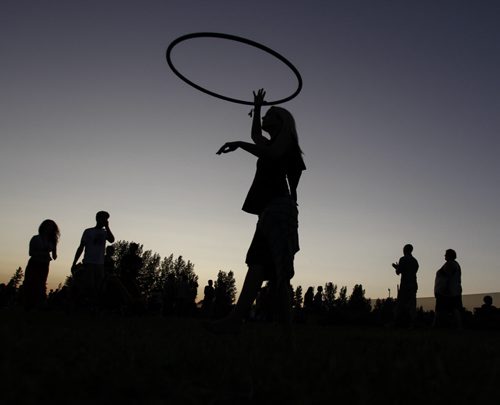 Alyx Monteith of Regina, Sask. is silhouetted against the sky at dusk while hula hooping on Day 3 of the 40th annual Winnipeg Folk Festival at Birds Hill Provincial Park. Friday, July 12, 2013. (JESSICA BURTNICK/WINNIPEG FREE PRESS)