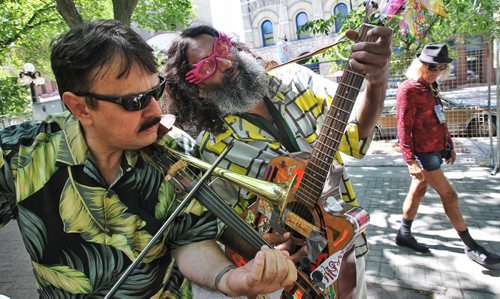 Kumara Reddy on guitar helps John Racaru tune his Trumpolin back stage at the Soca Reggea Festival at the Old Market Stage in the Exchange District Sunday afternoon.  130714 July 14, 2013 Mike Deal / Winnipeg Free Press