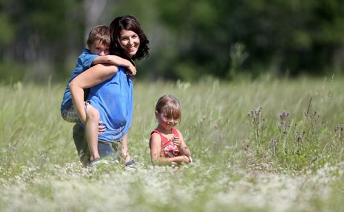 Adrienne with Noah and Hannah in a field of wild flowers behind their farm. Adrienne and Trevor Percy, their son Noah, 9 and daughter Hannah, 6, live at Nourished Roots, their homestead north of Teulon, Tuesday, July 16, 2013. (TREVOR HAGAN/WINNIPEG FREE PRESS) - for alex paul story