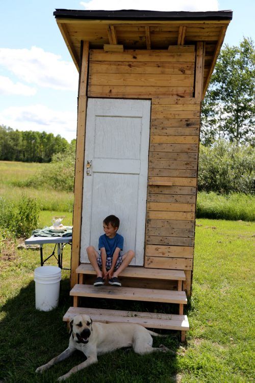 Noah and Rex by the steps of the newly built composting tiolet. Adrienne and Trevor Percy, their son Noah, 9 and daughter Hannah, 6, live at Nourished Roots, their homestead north of Teulon, Tuesday, July 16, 2013. (TREVOR HAGAN/WINNIPEG FREE PRESS) - for alex paul story