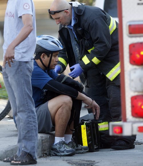 Wpg Fire and paramedic Service treated a cyclist struck by a car on Sherbrook  St at Sargent Ave just after 7am , the cyclist was treated for a head injury  KEN GIGLIOTTI / JULY 19 2013 / WINNIPEG FREE PRESS