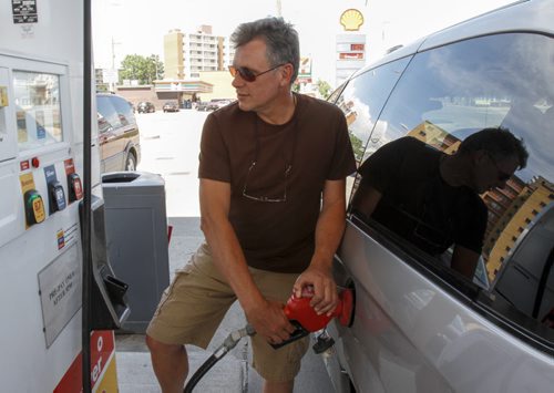 Peter Buchhold fills up at a local gas station in Winnipeg. Gas prices have dropped to 130.9 cents per litre at gas station locations across the city, such as this Shell station on St. Mary's St. on Friday, July 19, 2013. (JESSICA BURTNICK/WINNIPEG FREE PRESS)