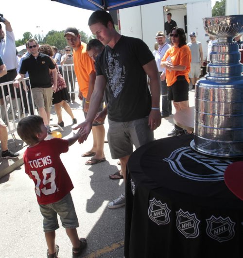 William Bader,4, meets his hero Chicago Blackhawks Captain Jonathan Toews at the event outside the  the Jonathan Toews Community Centre Friday afternoon. William wore this shirt for 26 days during the playoffs.  Randy Turner story Wayne Glowacki/Winnipeg Free Press July 19 2013