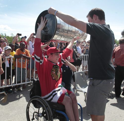 Chicago Blackhawks Captain Jonathan Toews lets neighbour Cameron MacDonald handle the Stanley Cup at the event outside the Jonathan Toews Community Centre Friday afternoon. .  Randy Turner story Wayne Glowacki/Winnipeg Free Press July 19 2013