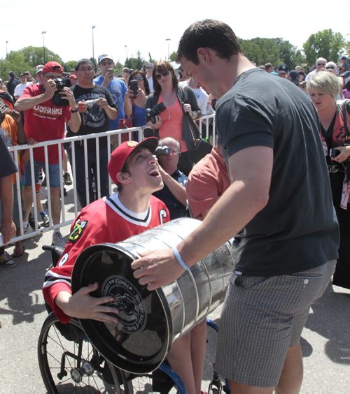 Chicago Blackhawks Captain Jonathan Toews lets his neighbour Cameron MacDonald handle the Stanley Cup at the event outside the Jonathan Toews Community Centre Friday afternoon.   Randy Turner story Wayne Glowacki/Winnipeg Free Press July 19 2013