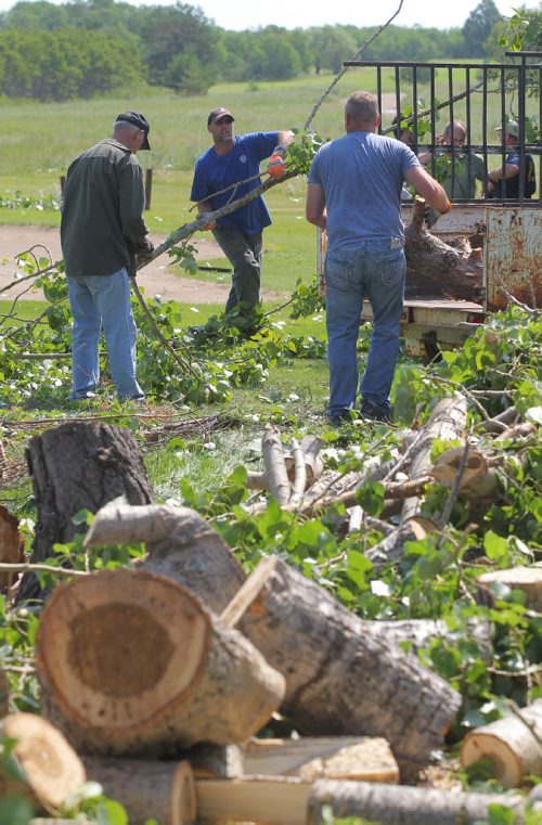 Brandon Sun Volunteers from the public and base personnel work together to clear the debris of fallen trees from the seventeenth hole of the Shilo Golf and Country Club on Friday morning. (Bruce Bumstead/Brandon Sun)