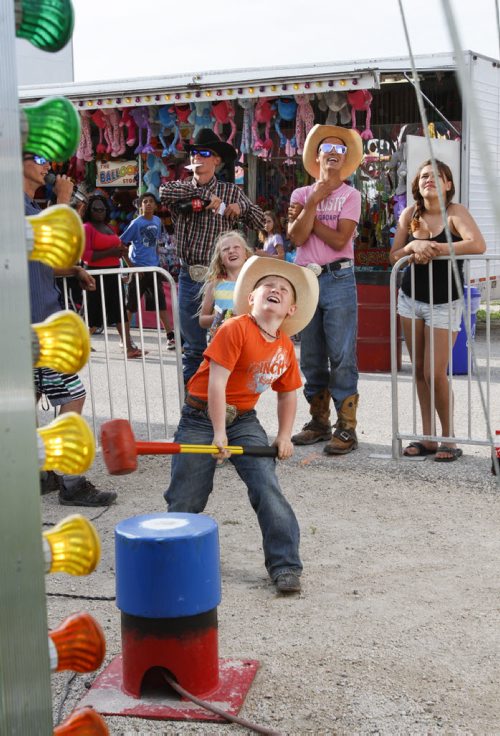 Ten year old Morgan Anderson from Saskatchewan takes a swing at the Lucky Strike game on the midway while sister Katie, 7, watches from the sidelines. The Manitoba Stampede and Exhibition celebrates its 50th year this weekend. Friday, July 19, 2013. (JESSICA BURTNICK/WINNIPEG FREE PRESS)