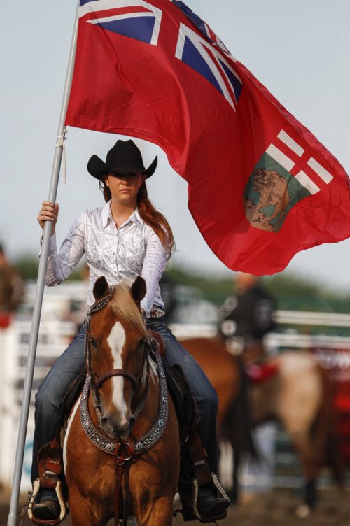 A flag carrier holds the Manitoba flag in the rodeo arena at the Manitoba Stampede and Exhibition as it celebrates its 50th year this weekend. Friday, July 19, 2013. (JESSICA BURTNICK/WINNIPEG FREE PRESS)