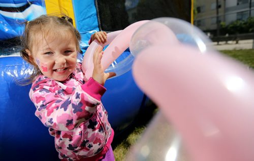Alaska Kent, 2, plays with her balloon hat while at the 4th Annual North End Family Center barbecue, Saturday, July 20, 2013. (TREVOR HAGAN/WINNIPEG FREE PRESS)