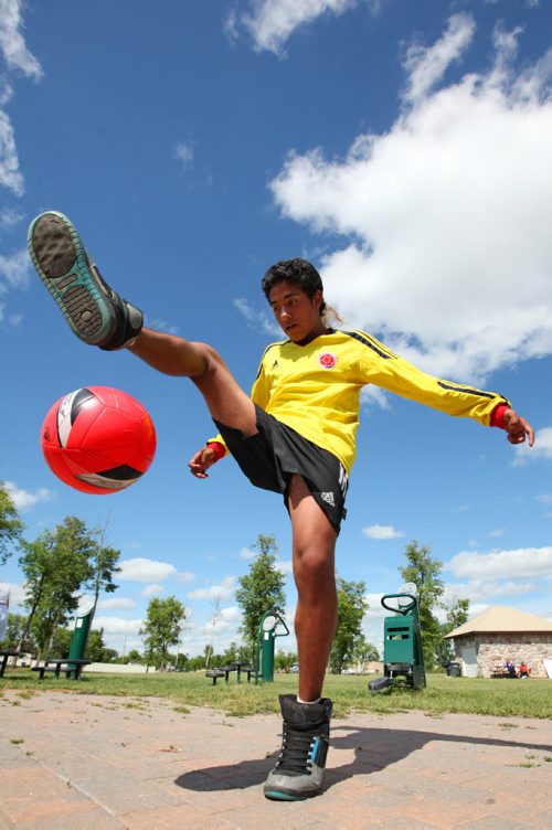 Brandon Sun 20072013 Juan Manual Aguirre does some fancy foot work with a soccer ball during Colombian Independence Day celebration's at the First Street spray park on Saturday afternoon. Brandon's Colombian community gathered for games, a barbecue, dancing and other events.  (Tim Smith/Brandon Sun)