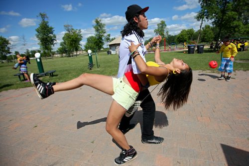 Brandon Sun 20072013 Jonathan Aguirre and Paula Aguirre dance the Salsa during Colombian Independence Day celebration's at the First Street spray park on Saturday afternoon. Brandon's Colombian community gathered for games, a barbecue, dancing and other events.  (Tim Smith/Brandon Sun)