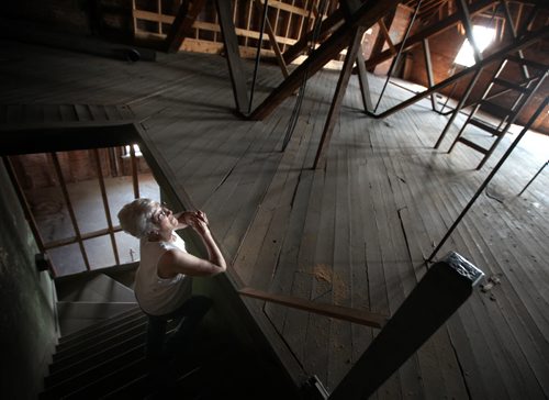 Carberry Heritage spokeswoman Penny Shaw gazes up from a third storey stairwell at unique "suspended" beams supporting the third floor from the ceiling in an empty but ornate bank buiding on the town's Main Street. See Bill Redekop's story. July 23, 2013 - (Phil Hossack / Winnipeg Free Press)