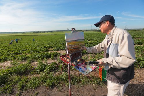 Brandon Sun Local artist Weiming Zhao works on a painting at the Grandvalley Berry Farm for an upcoming show on Wednesday morning. (Bruce Bumstead/Brandon Sun)
