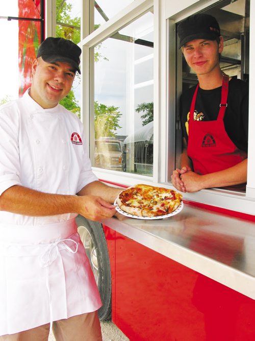 Canstar Community News July 17, 2013 - Owner Steffen Zinn, of Starbuck, shows off one of the freshly made pizzas baked in a wood-fired oven inside his Red Ember food truck. (ANDREA GEARY/CANSTAR)