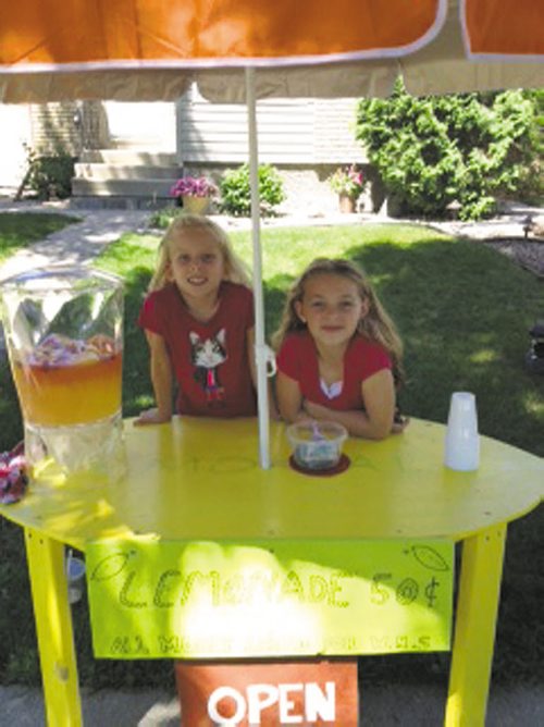 Canstar Community News July 18 -- Emily Enns (standing) and Taylor Allen, both eight years old, ran a lemonade stand outside Emily's River Park South home two weekends ago, hoping to raise money for the Winnipeg Humane Society. The enterprising pair earned $112.66. SUPPLIED PHOTO LANCE