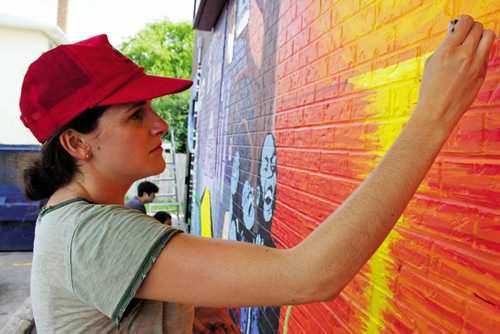 Canstar Community News July 18, 2013 -- River Heights artist Rachel OíConnor puts some finishing touches on a new mural featured on the side of the neighbourhood 7-Eleven at Mountain Avenue and McPhillips Street.