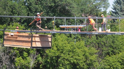 Brandon Sun Construction continues on the Souris suspension bridge as workers lay down new bridge decking on the cables over the Souris River on Wednesday. (Bruce Bumstead/Brandon Sun)