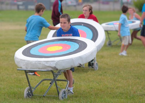 Brandon Sun MOVING TARGET -- Logan Leensbak helps to wheel in the archery targets at Brandon University during Thursday's Mini-U activities. Archery lessons where called off early because of windy weather which play havoc with the light foam targets. (Bruce Bumstead/Brandon Sun)