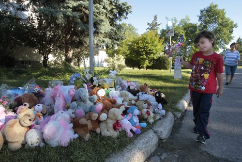 Four year old Brayden Polowick and his great grandmother Emily Polowick bring flowers to the  memorial Friday morning of stuffed toys, flowers and messages by the Coleridge Park Drive home were two children died Wednesday. The police tape has been removed and the police are no longer stationed outside the residence. Wayne Glowacki / Winnipeg Free Press July 26 2013
