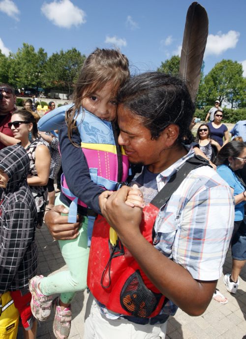 Tears of joy from paddler Nathan Beardy  reunited with his daugher Kamara age 4 on dock after arrival- Fourteen paddlers from  the Pimicikamak  Cree First Nation  arrived at the Forks after a grueling 19 day 890 km trip  the  Ininiwi Aski Quest advocates for the protection of Lake Winnipeg . KEN GIGLIOTTI / JULY 26 2013 / WINNIPEG FREE PRESS