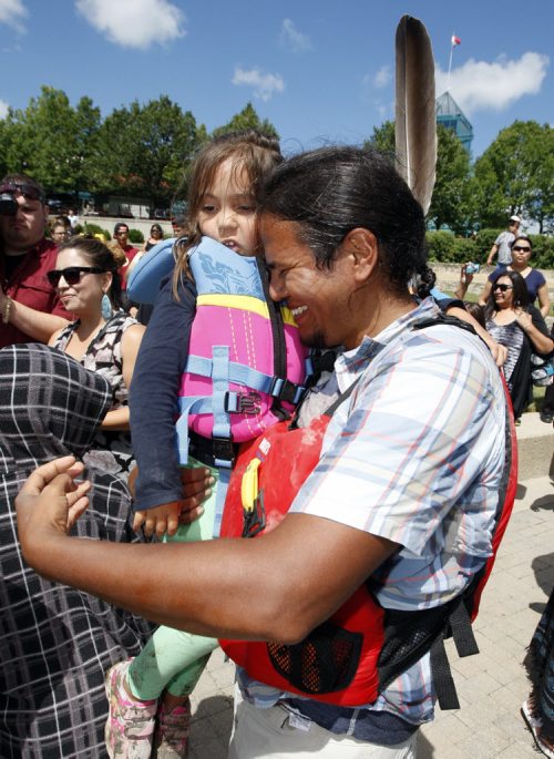 Tears of joy from paddler Nathan Beardy as he is reunited with his daughter Kamara  age on the dock -Fourteen paddlers from  the Pimicikamak  Cree First Nation  arrived at the Forks after a grueling 19 day 890 km trip  the  Ininiwi Aski Quest advocates for the protection of Lake Winnipeg . KEN GIGLIOTTI / JULY 26 2013 / WINNIPEG FREE PRESS
