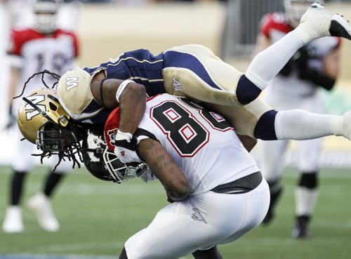 Alex Suber (#21) jumps on the back of Greg Carr (#88) in an attempt to gain control of the ball. The Winnipeg Blue Bombers faced off against the Calgary Stampeders at home on Friday, July 26, 2013. (JESSICA BURTNICK/WINNIPEG FREE PRESS)