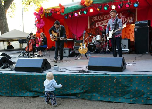 Brandon Sun 26072013 JP Hoe locks eyes with 15-month-old Maxwell May-Lumgair while performing on the opening night of the 29th Annual Brandon Folk, Music and Art Festival in Brandon on Friday evening. (Tim Smith/Brandon Sun)