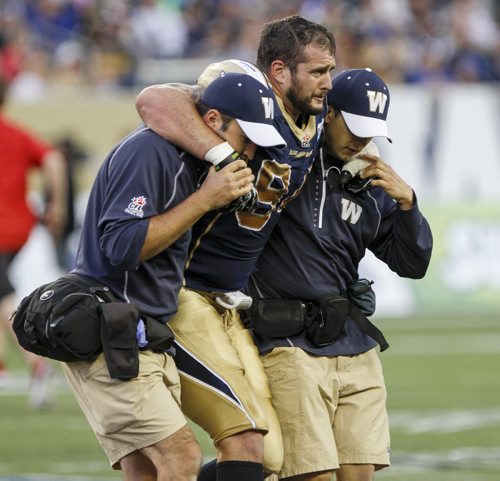Ryan Lucas (#94) sustained an injury during gameplay and is escorted off the field. The Winnipeg Blue Bombers faced off against the Calgary Stampeders at home on Friday, July 26, 2013. (JESSICA BURTNICK/WINNIPEG FREE PRESS)