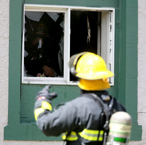 Firefighters on the scene of a fire at a two storey apartment building at the corner of Stella and Powers, Saturday, July 27, 2013. (TREVOR HAGAN/WINNIPEG FREE PRESS)