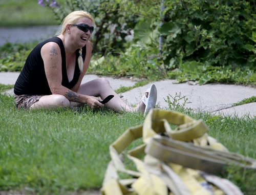 An emotional woman outside a fire at a two storey apartment building at the corner of Stella and Powers, Saturday, July 27, 2013. (TREVOR HAGAN/WINNIPEG FREE PRESS)