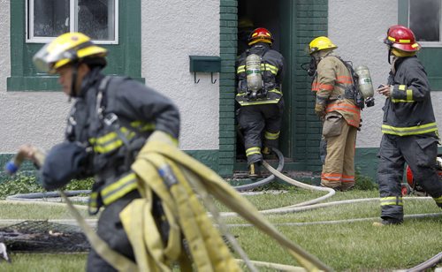 Firefighters start to fight a fire inside a two storey apartment building at the corner of Stella and Powers, Saturday, July 27, 2013. (TREVOR HAGAN/WINNIPEG FREE PRESS)