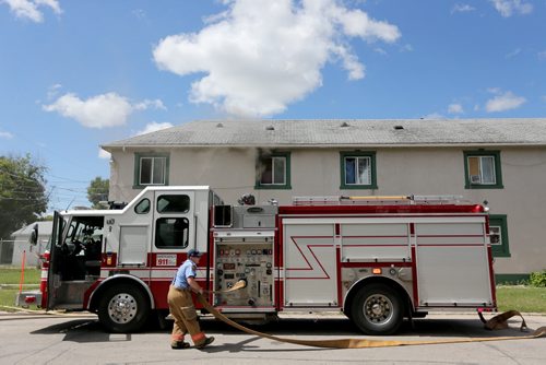 Firefighters start to fight a fire inside a two storey apartment building at the corner of Stella and Powers, Saturday, July 27, 2013. (TREVOR HAGAN/WINNIPEG FREE PRESS)