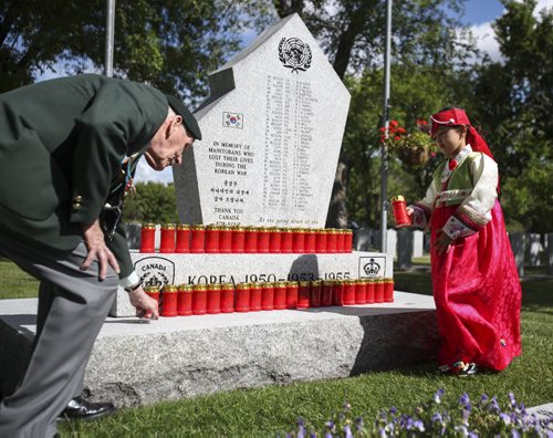 A member of the Korean community in Winnipeg places a candle at the Korea War memorial monument at Brookside Cemetery. A candle light service was held by the Korea Veterans Association on Saturday, July 27, 2013 to mark the 60th anniversary of the Korean War ceasefire. The service also recognized the designation of 2013 as The Year of the Korea War Veteran by the Canadian government. Five hundred and sixteen Canadians gave their lives in the Korean War, which lasted three years and ended on July 27, 1953.  (MARY AGNES WELCH) (JESSICA BURTNICK/WINNIPEG FREE PRESS)