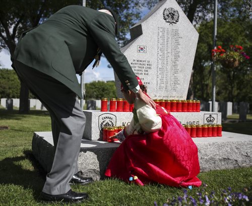 A member of the Korean community in Winnipeg places a candle at the Korea War memorial monument at Brookside Cemetery. A candle light service was held by the Korea Veterans Association on Saturday, July 27, 2013 to mark the 60th anniversary of the Korean War ceasefire. The service also recognized the designation of 2013 as The Year of the Korea War Veteran by the Canadian government. Five hundred and sixteen Canadians gave their lives in the Korean War, which lasted three years and ended on July 27, 1953.  (MARY AGNES WELCH) (JESSICA BURTNICK/WINNIPEG FREE PRESS)