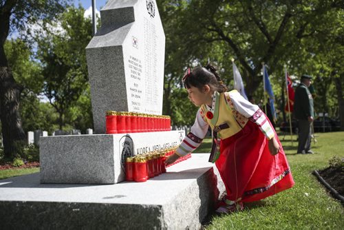 Five year old Kaiya Yoon-Macrae, a member of the Korean community in Winnipeg, places a candle at the Korea War memorial monument at Brookside Cemetery. A candle light service was held by the Korea Veterans Association on Saturday, July 27, 2013 to mark the 60th anniversary of the Korean War ceasefire. The service also recognized the designation of 2013 as The Year of the Korea War Veteran by the Canadian government. Five hundred and sixteen Canadians gave their lives in the Korean War, which lasted three years and ended on July 27, 1953.  (MARY AGNES WELCH) (JESSICA BURTNICK/WINNIPEG FREE PRESS)