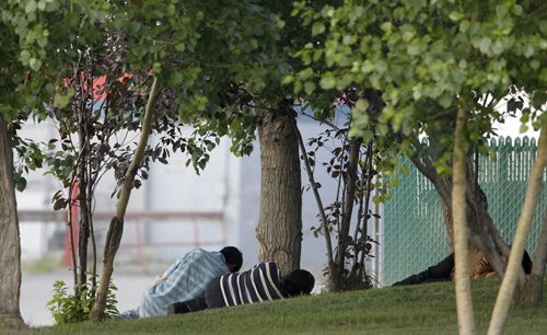 People sitting under some trees near Walmart in Thompson, Monday, July 22, 2013. (TREVOR HAGAN/WINNIPEG FREE PRESS)