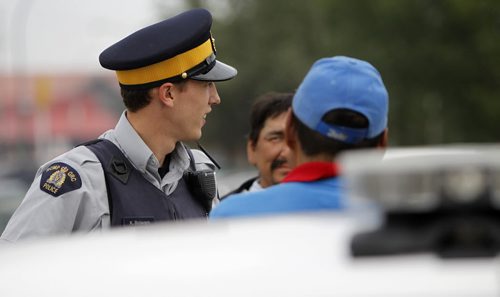 RCMP Special Const. Kyle Boisvert speaking with members of the community, in Thompson, Tuesday, July 23, 2013. (TREVOR HAGAN/WINNIPEG FREE PRESS)