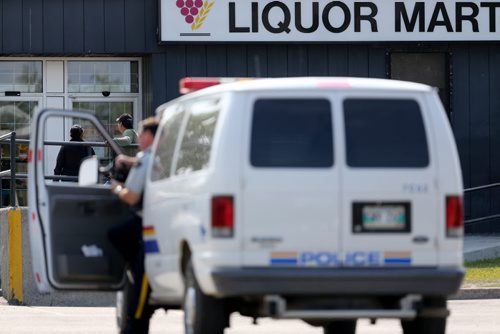 RCMP officers outside the Liquor Commission in Thompson as customers wait for it to open at 11am, Monday, July 22, 2013. (TREVOR HAGAN/WINNIPEG FREE PRESS)