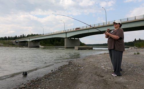Regina Gibbons fishing on the Burntwood River in front of the Miles Hart Bridge in Thompson, Monday, July 22, 2013. (TREVOR HAGAN/WINNIPEG FREE PRESS)